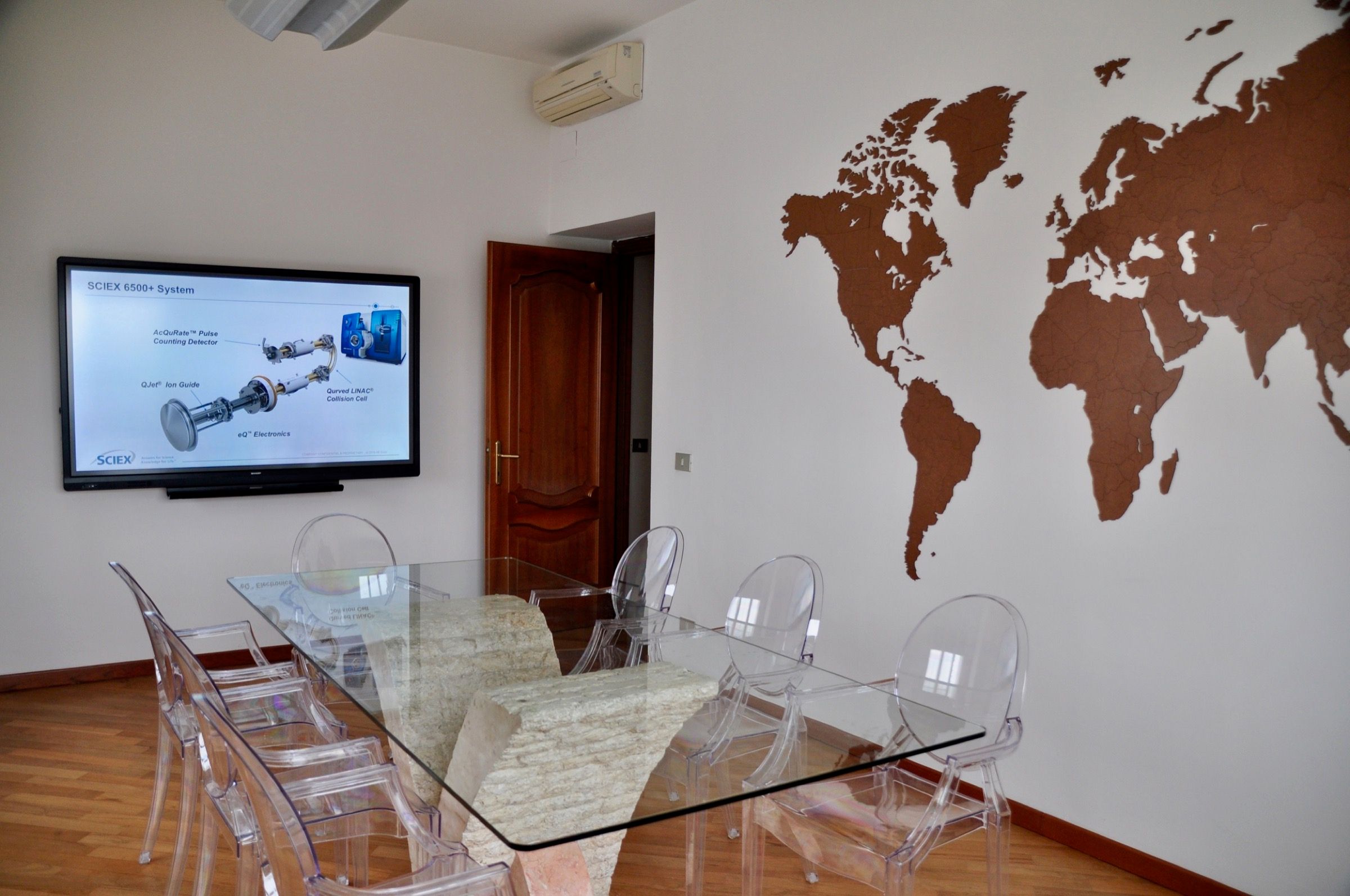 The meeting room at the DaSP office: the table, the screen and the world map on the wall